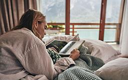 Frau liest auf dem Bett - Travel Charme Fürstenhaus am Achensee in 6213 Pertisau am Achensee